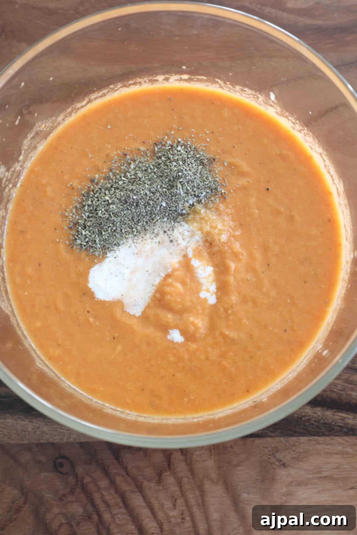 Hearty Roasted Tomato Soup 9 A close-up shot of creamy tomato soup, elegantly garnished with a dash of freshly ground black pepper and a sprinkle of sea salt, enhancing its visual appeal.