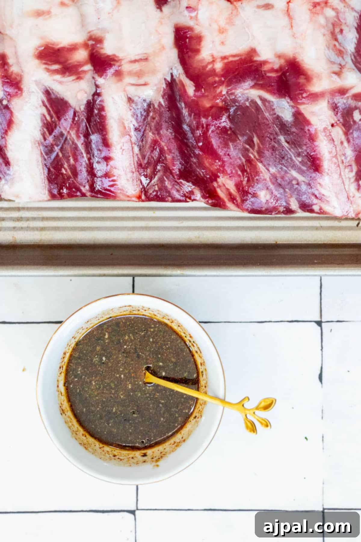 A serving of perfectly cooked oven-baked beef ribs, coated in a glistening, tangy sauce, beautifully presented on a plate.