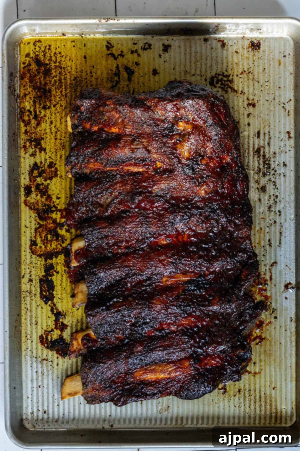 Another enticing view of perfectly baked beef ribs on a baking sheet, highlighting the even seasoning and delicious aroma.