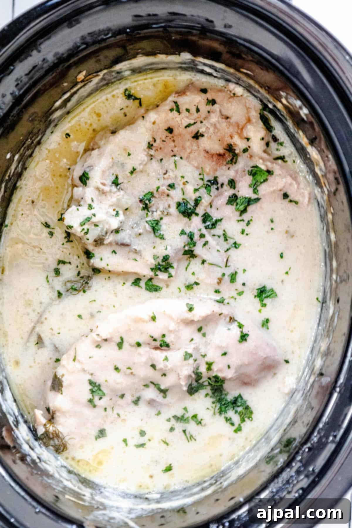 Slow Cooker Creamy Ranch Pork Chops 10 A crock pot filled with creamy chicken and gravy, showcasing a similar rich texture.