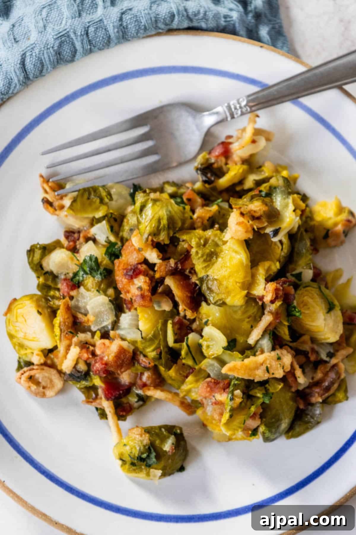 Bacon Brussels Bliss 4 Creamy Brussels sprouts and bacon on a plate with a fork, ready to be eaten.