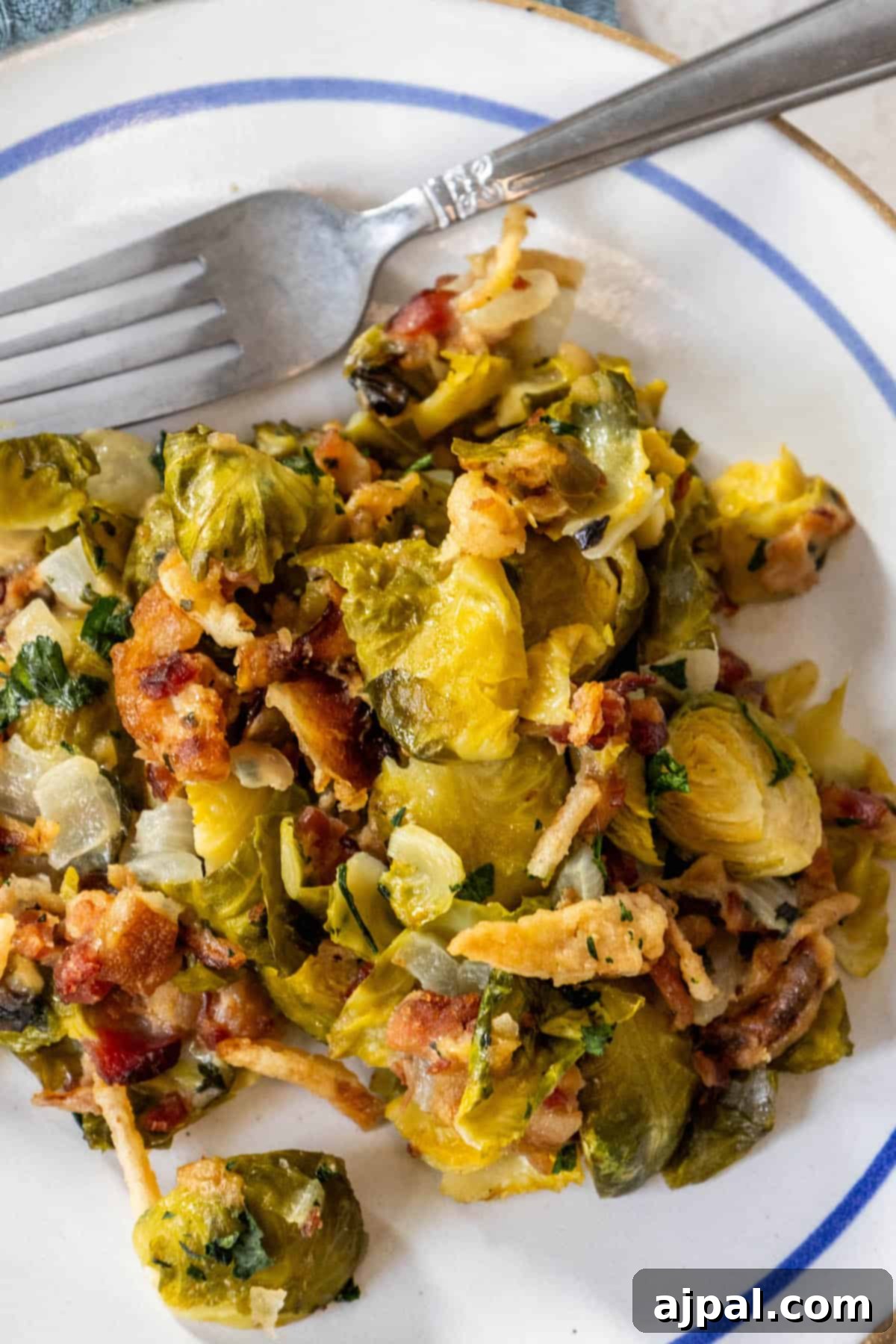 Bacon Brussels Bliss 6 Brussels sprouts and bacon on a plate with a fork, creating a creamy and savory delight.
