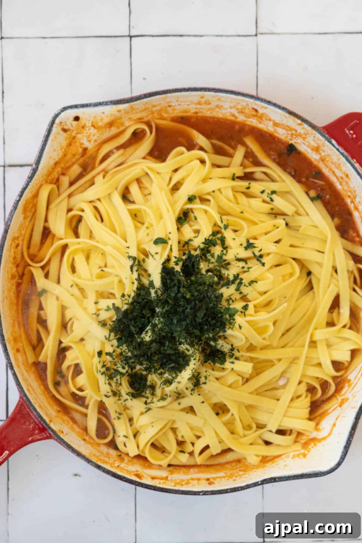 Exquisite Italian Lobster Pasta 12 A red skillet filled with Venetian Lobster Busara pasta.