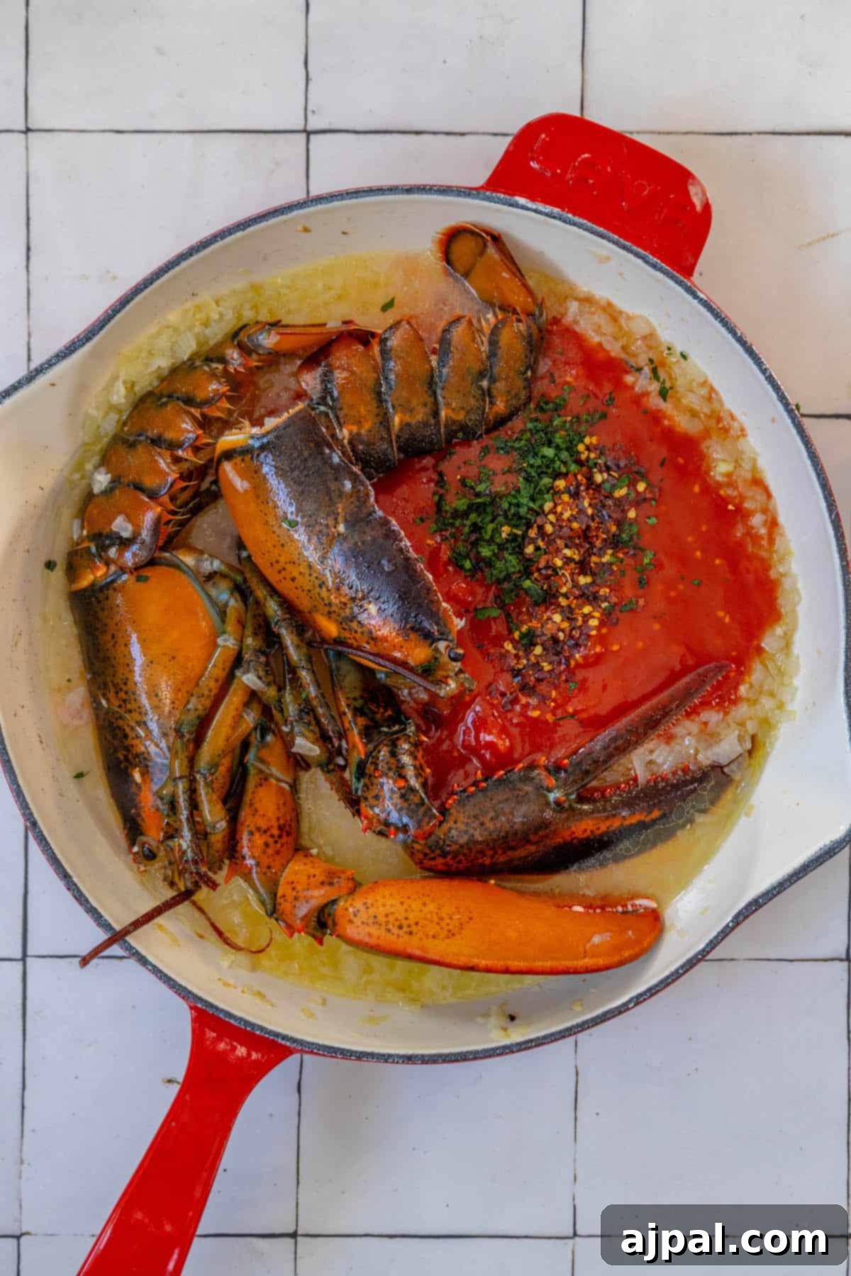 Exquisite Italian Lobster Pasta 10 Lobster in a red skillet with tomato sauce, inspired by Venice's Busara Pasta.