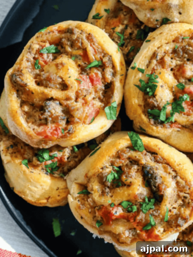 Golden brown Sausage Cream Cheese Pinwheels on a platter, ready to serve.