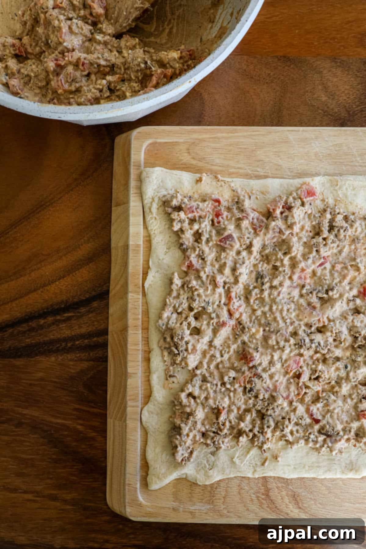 Crescent dough sheet laid out on a cutting board, ready for filling.