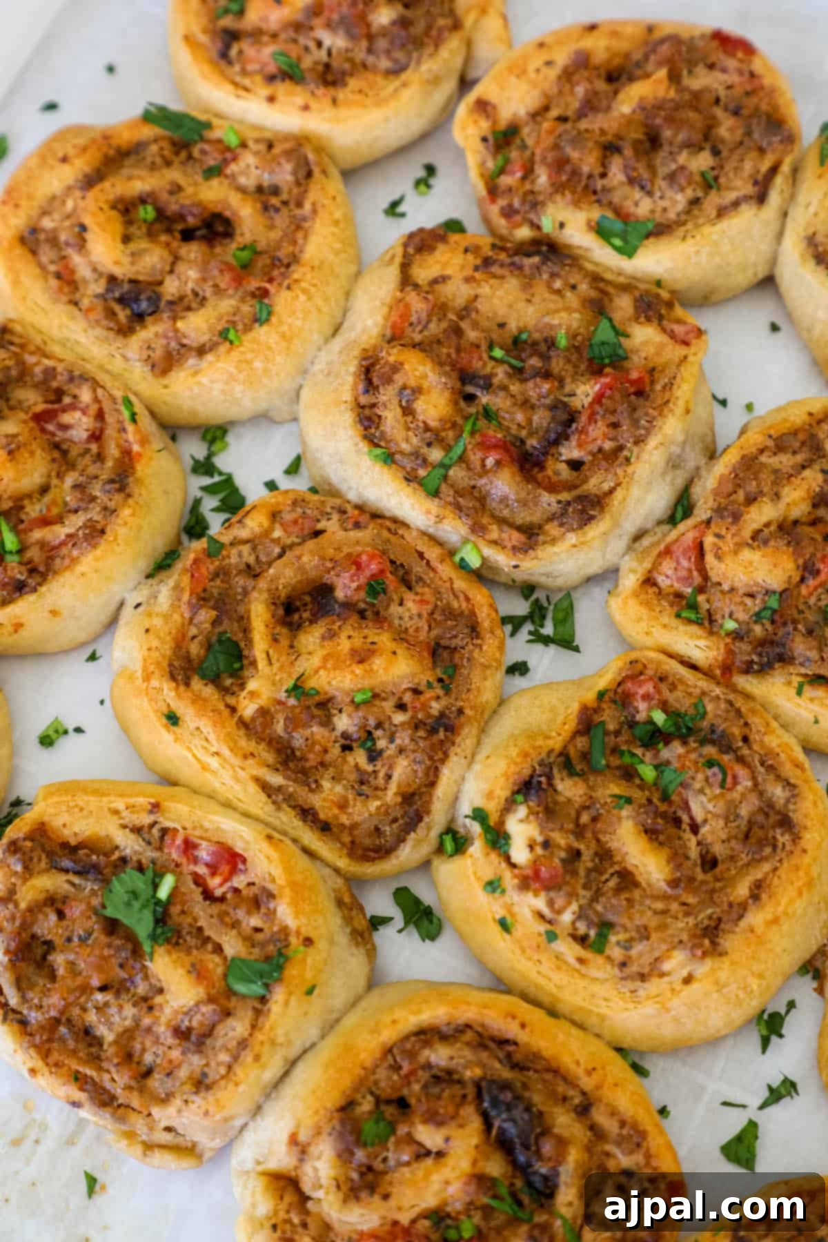 A close-up of baked sausage cream cheese pinwheels with golden-brown crusts.