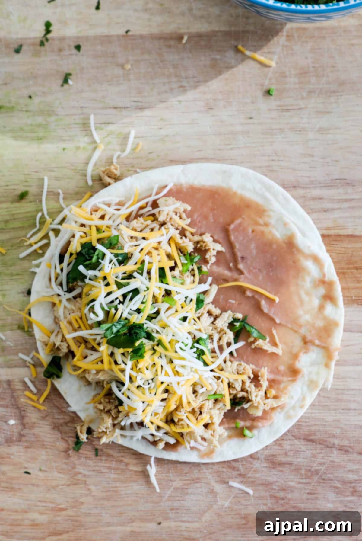 Bite-Sized Chicken Quesadillas 6 A mini taco is sitting on a cutting board next to a bowl of salsa.