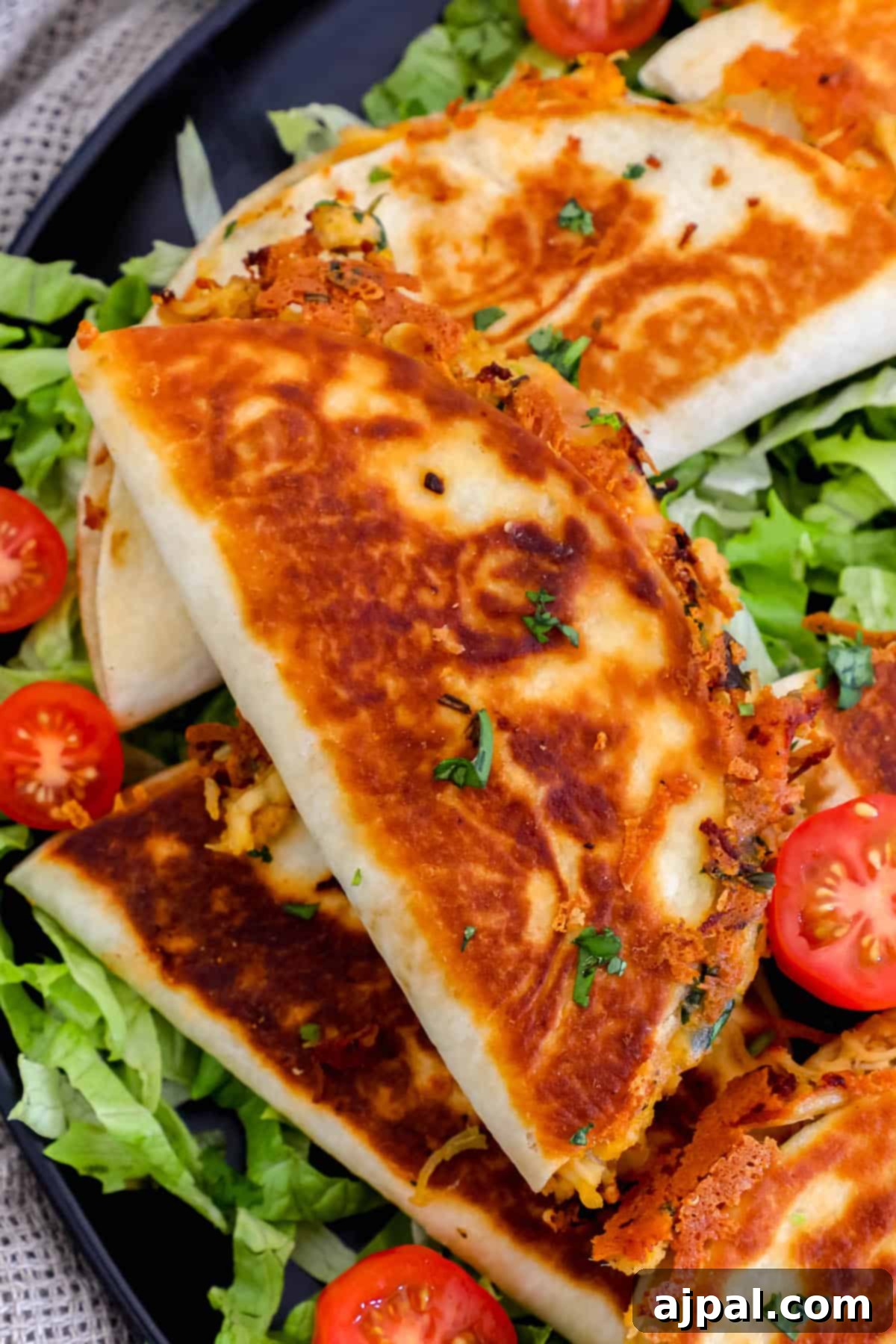 Bite-Sized Chicken Quesadillas 8 Mini chicken quesadillas on a plate with tomatoes and lettuce.
