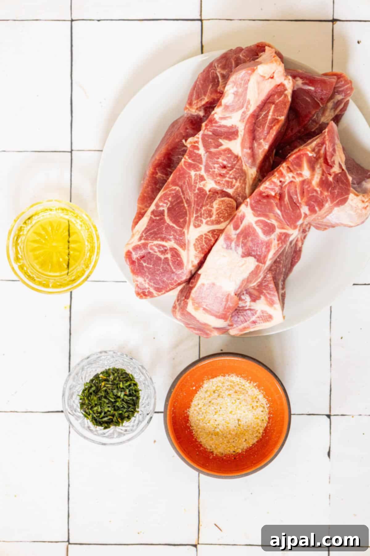 A plate of boneless BBQ country style ribs and spices on a tiled floor.