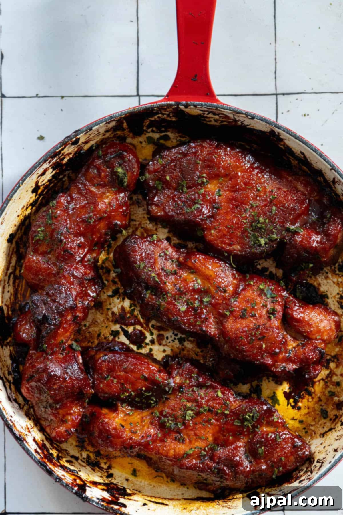 A red skillet with boneless BBQ country style ribs.