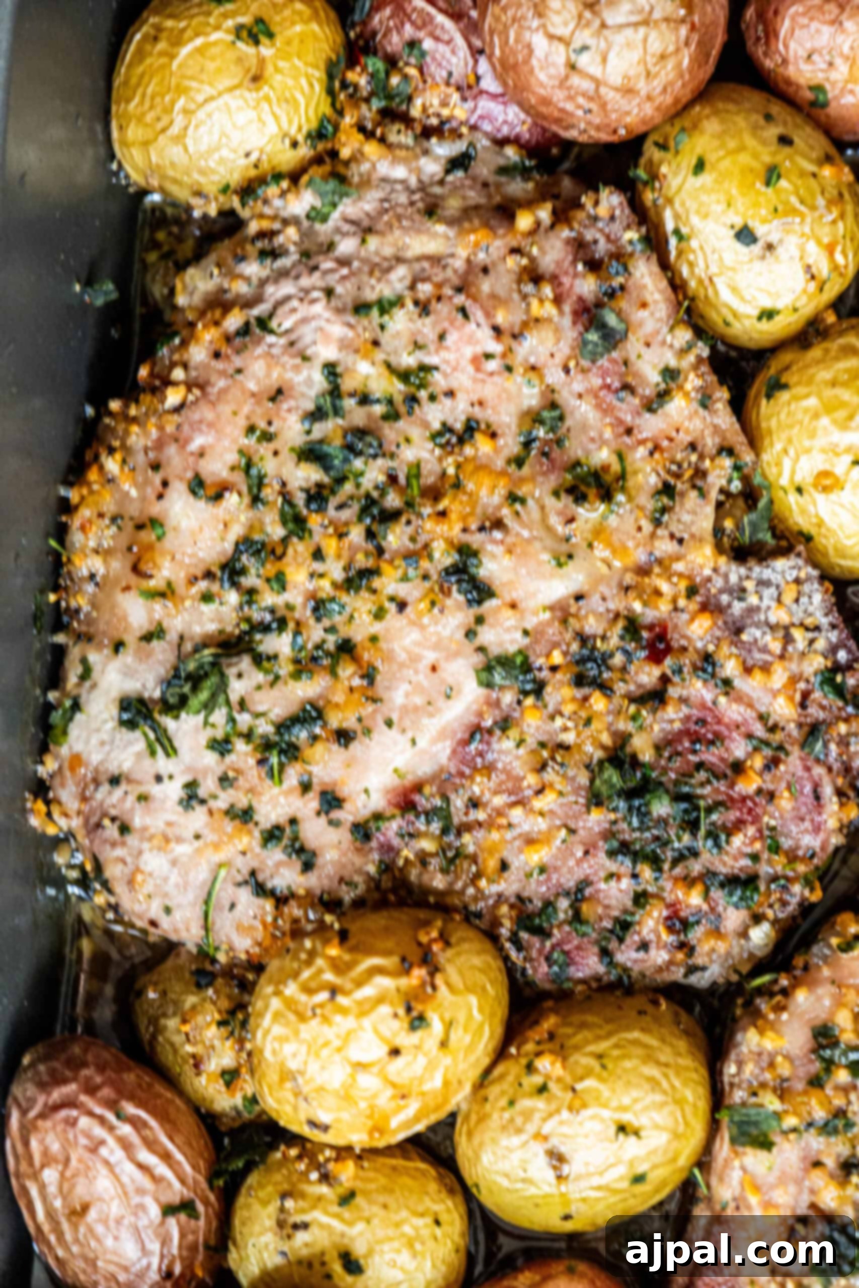 Hearty Pork Chops and Roasted Potatoes 11 Pork chops with potatoes and herbs cooked in a baking dish. The dish is golden brown and looks incredibly appetizing.