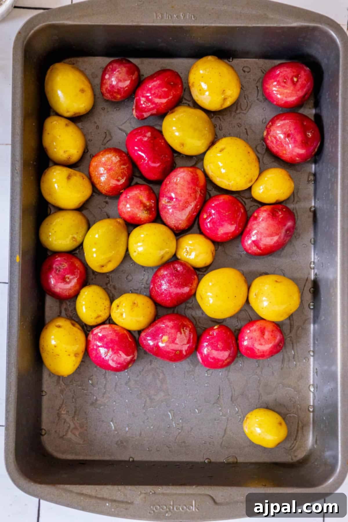 Hearty Pork Chops and Roasted Potatoes 7 Red tomatoes and yellow tomatoes in a baking pan, adding color to the roasted dish.