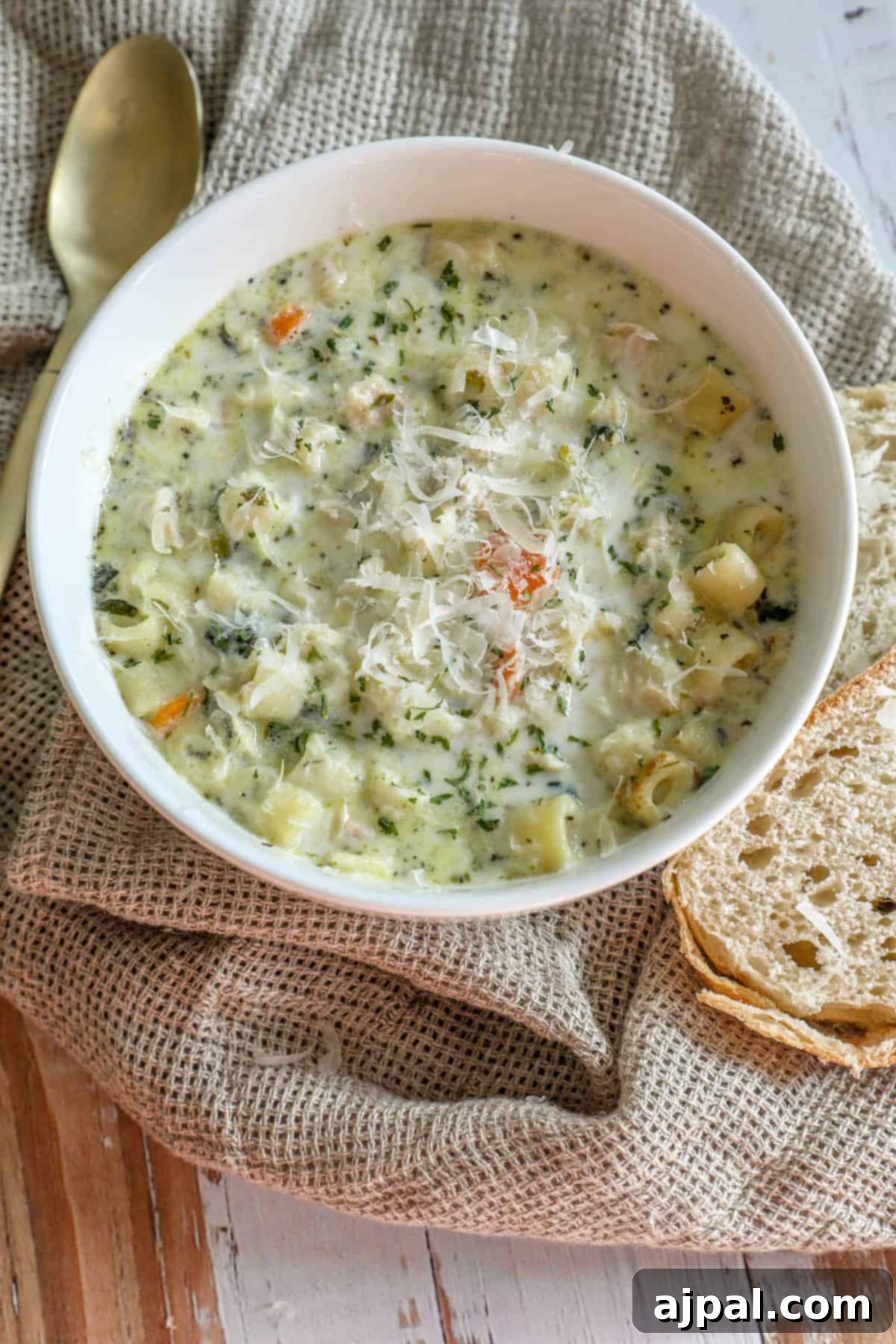 Velvety Creamy Chicken Noodle Soup 7 Creamy chicken noodle soup on a rustic wooden table, garnished with fresh herbs.