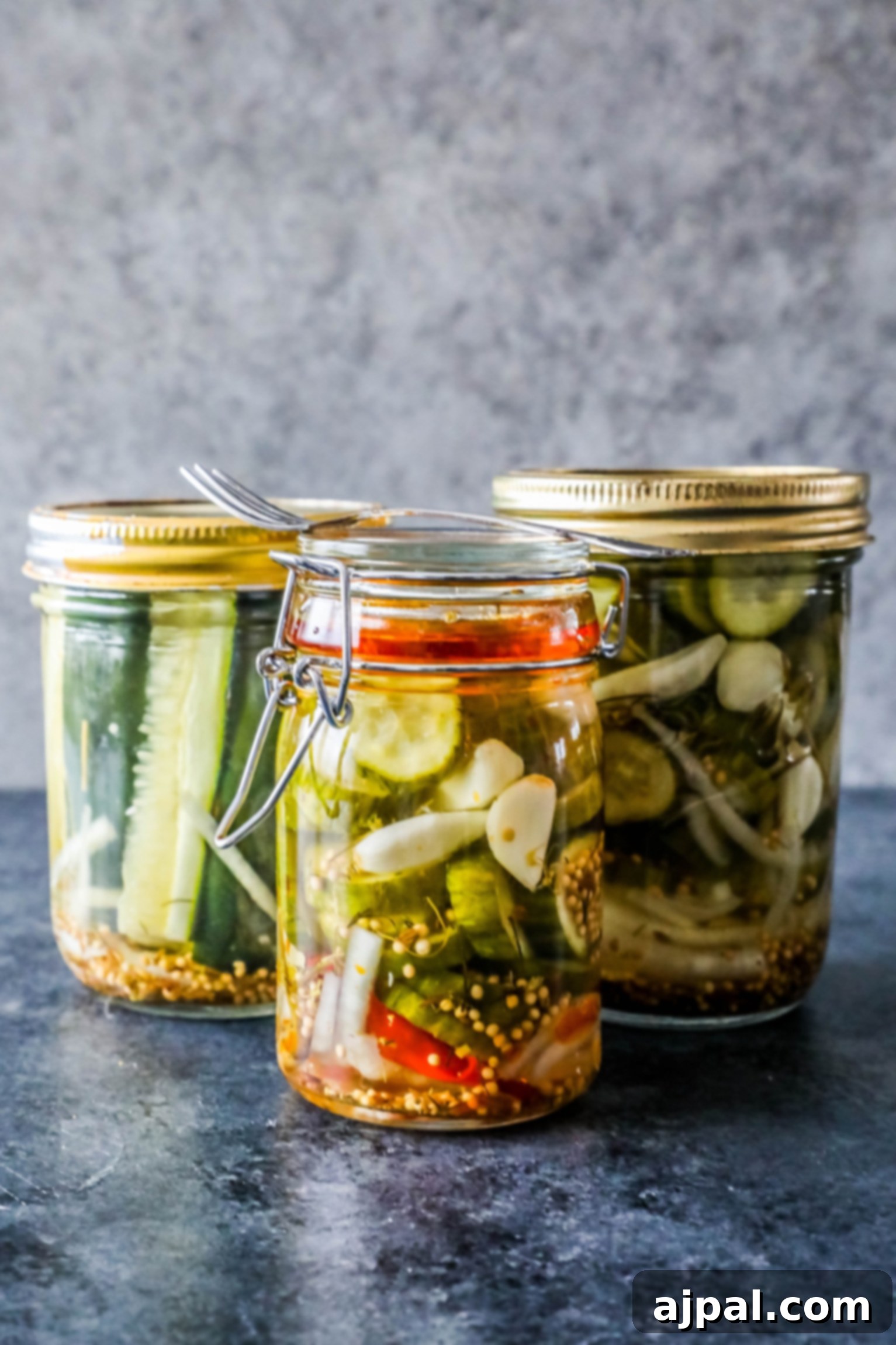 Quick Chill Pickles 2 Three jars of vibrant, quick refrigerator pickles on a rustic wooden table, ready to be enjoyed.