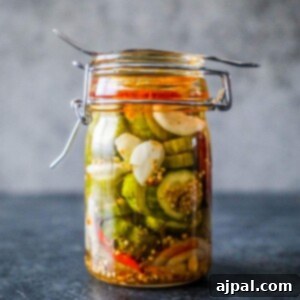 Quick Chill Pickles 7 10 Minute Fridge Pickles in a glass jar on a table.