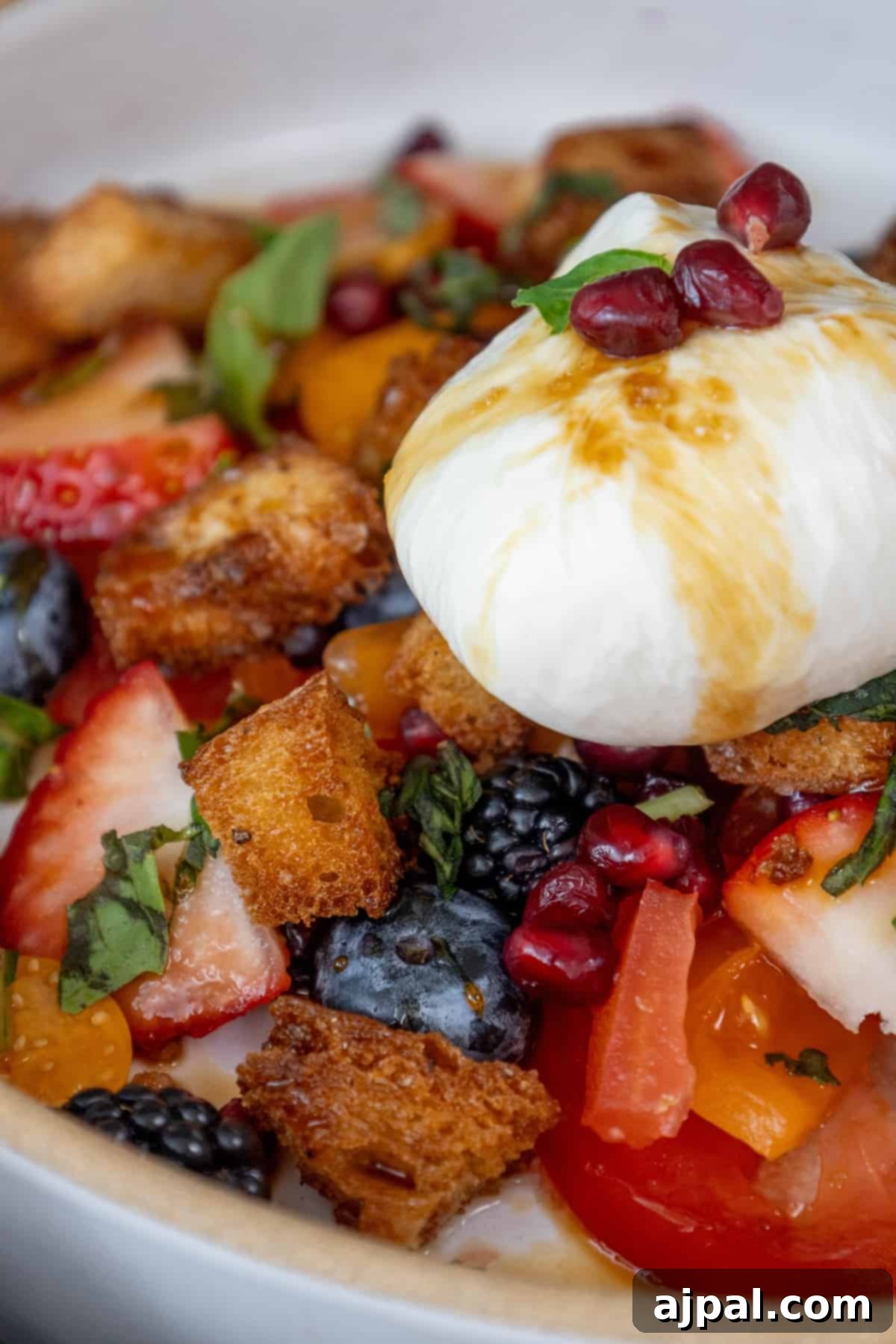 Summer Berry Burrata Medley 2 A vibrant bowl of Berry Burrata Salad, featuring creamy burrata, fresh mixed berries, and a drizzle of honey-date glaze.