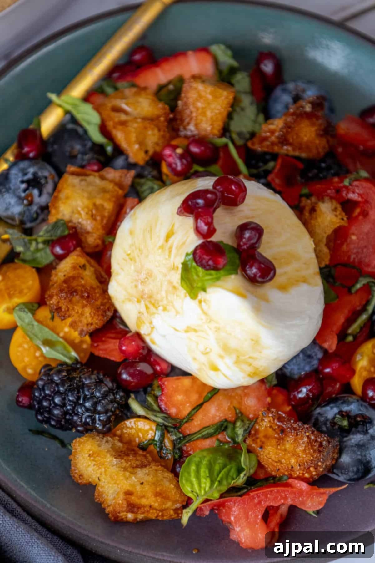 Summer Berry Burrata Medley 6 A close-up of a delightful berry salad, topped with a creamy element and fresh herbs, inviting a taste.