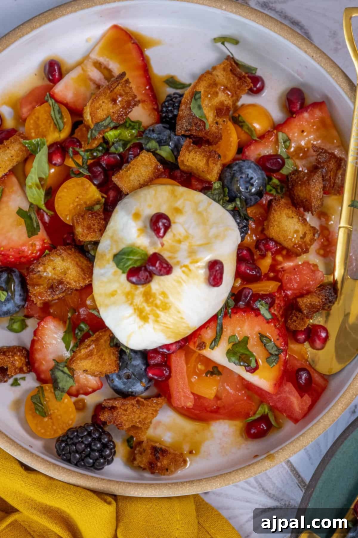 Summer Berry Burrata Medley 9 A plate of fruit salad with a poached egg on top.