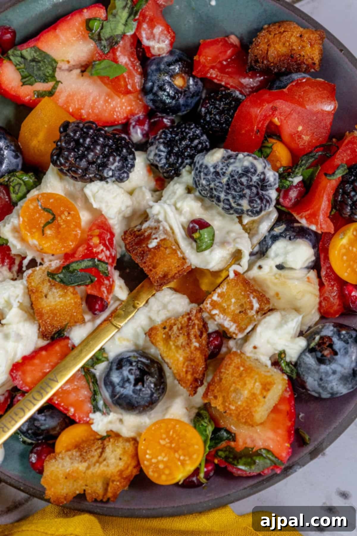 Summer Berry Burrata Medley 10 A bowl of vibrant fruit salad brimming with various berries.