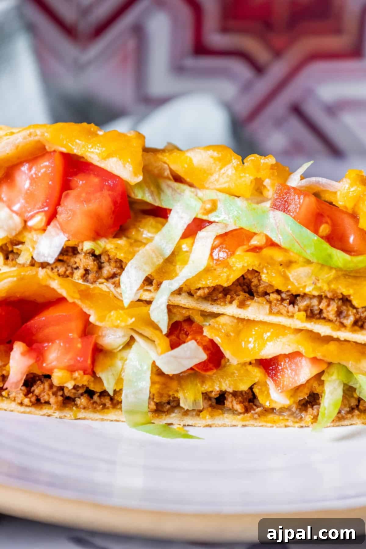 DIY Crunchwrap Delights 2 A stack of golden-brown homemade Crunchwraps on a plate, garnished with fresh tomatoes and crisp lettuce, ready to be enjoyed.
