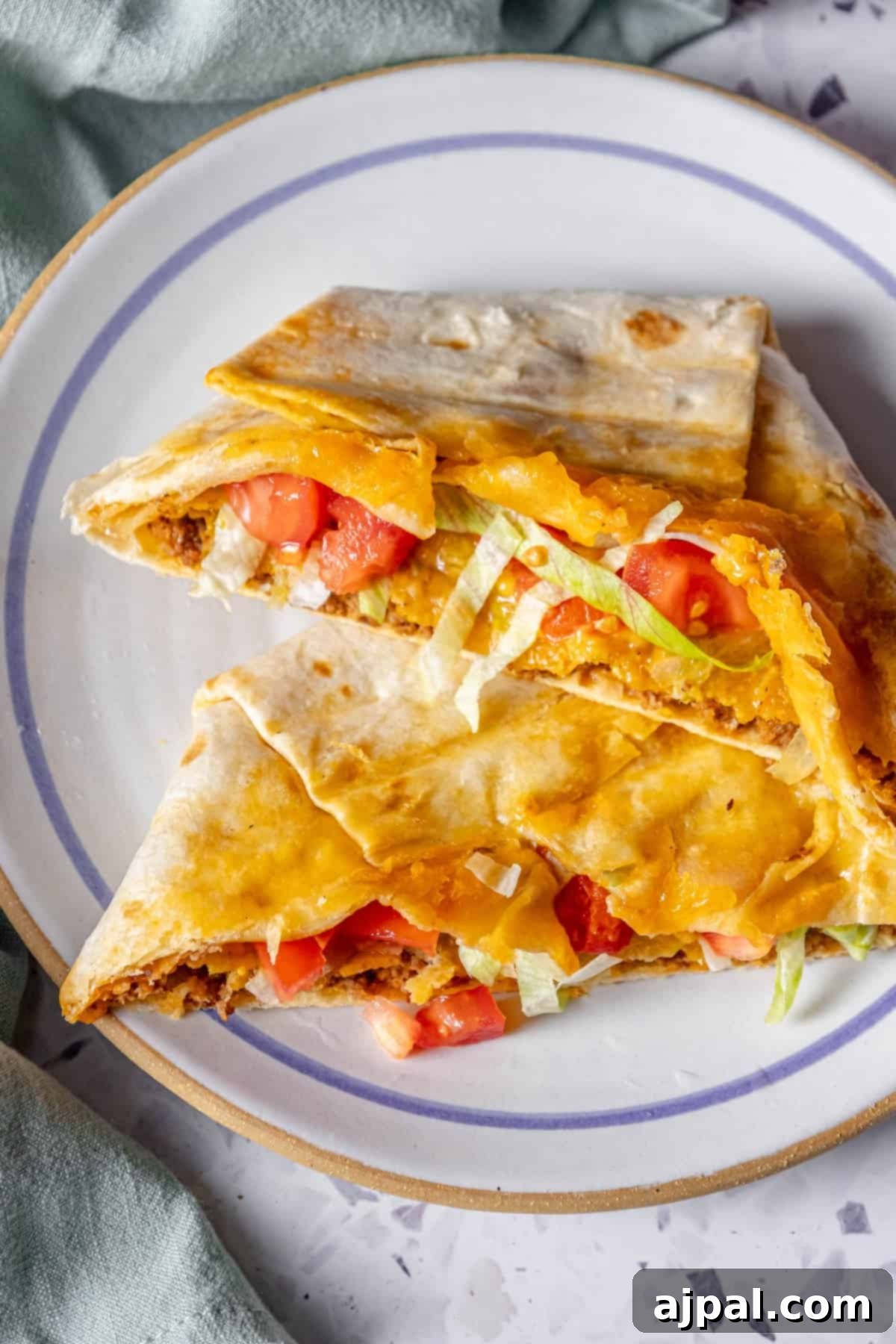 DIY Crunchwrap Delights 3 A beautifully assembled homemade chicken quesadilla, perfectly golden and ready to be sliced, on a clean white plate.
