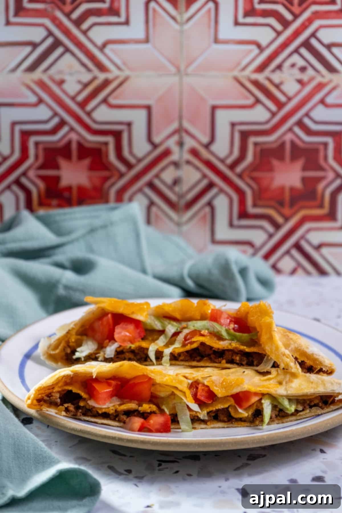 DIY Crunchwrap Delights 4 Several homemade quesadillas arranged on a plate against a stylish tiled wall, showcasing their golden-brown exterior and delicious fillings.