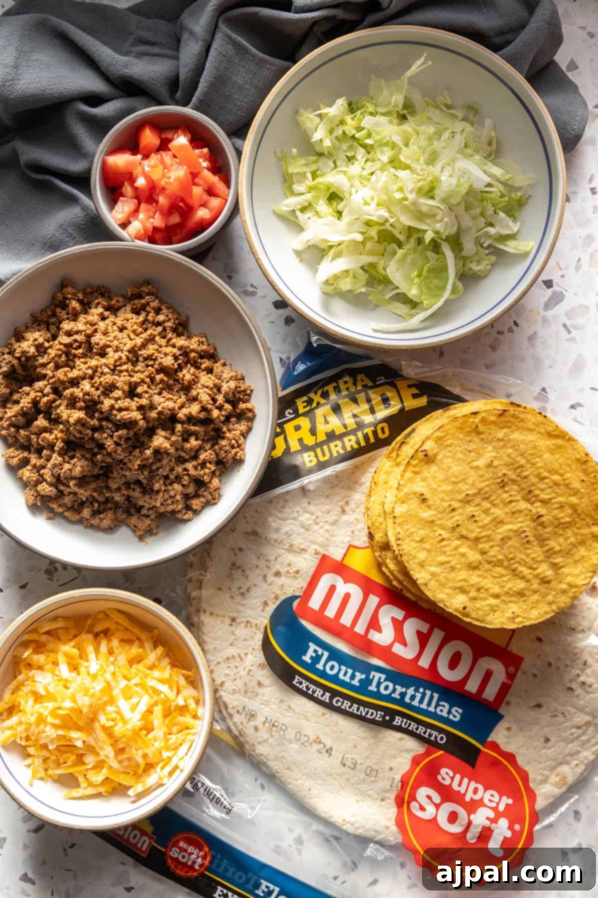 DIY Crunchwrap Delights 5 Ingredients for a homemade Mission Texas burrito laid out on a table, showcasing fresh produce, meat, and tortillas.