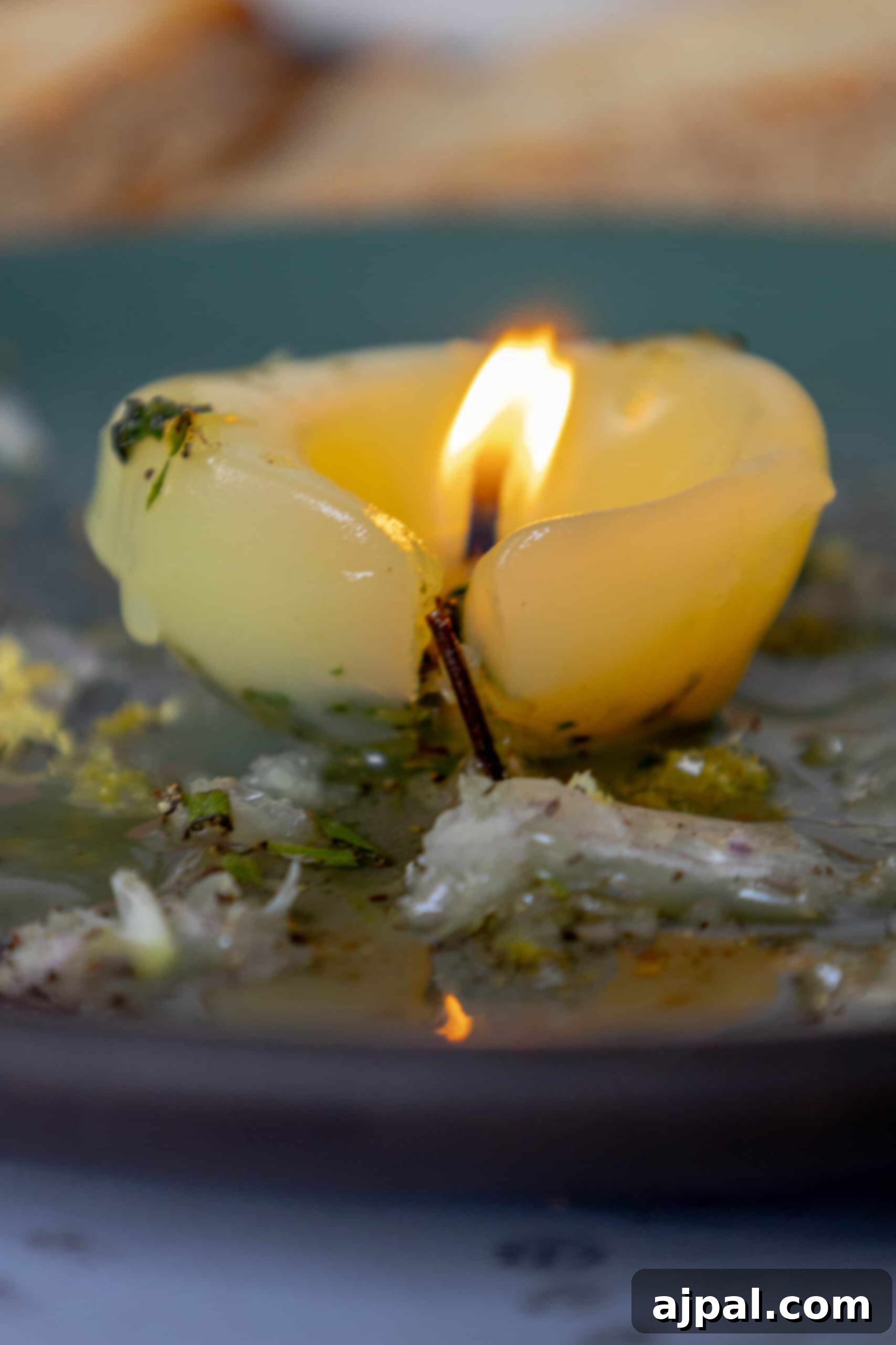 An edible tallow candle glowing warmly on a plate of food, highlighting its unique appeal.