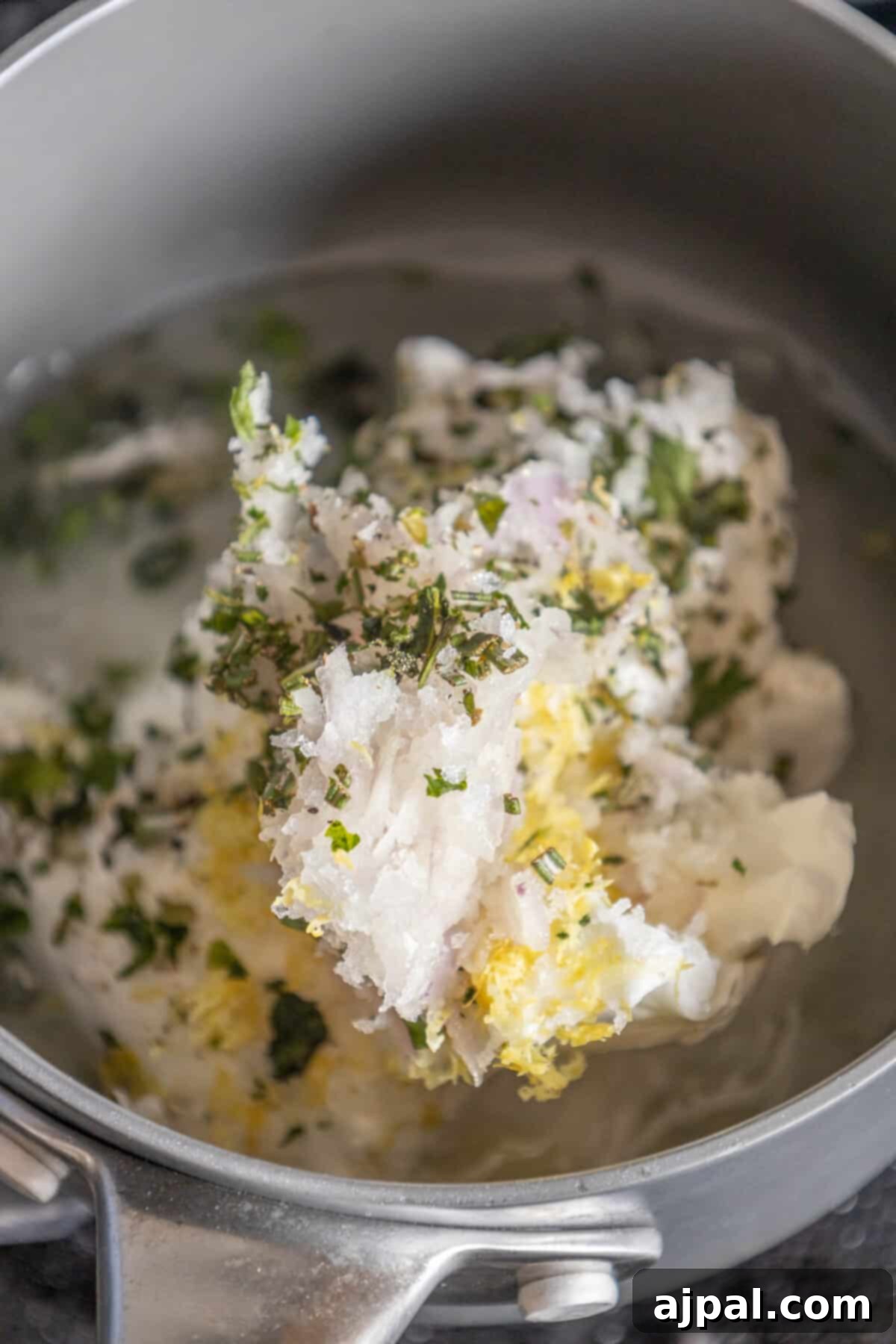 A close-up view of a pan containing a luscious blend of mashed potatoes and flavorful tallow candles, ready to be served.