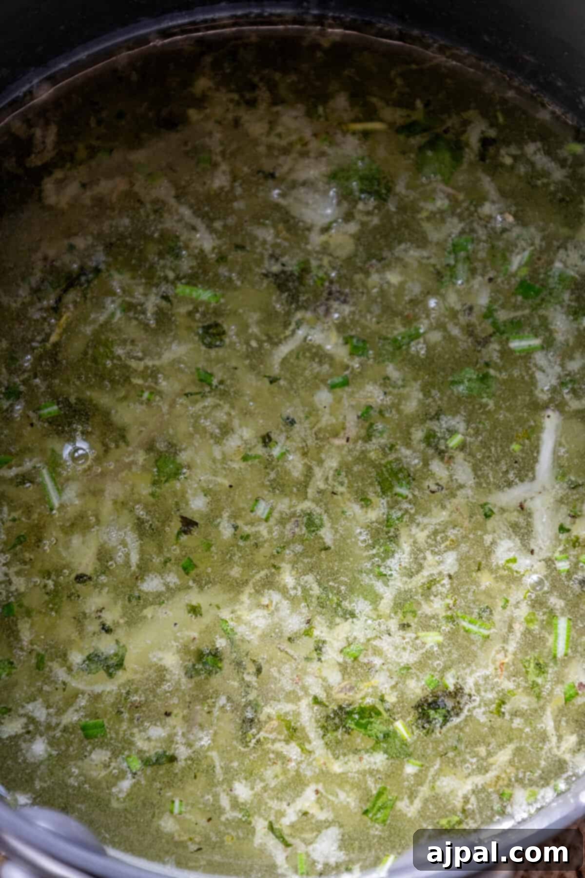 A hearty pot of soup, enriched with vibrant broccoli florets and garnished with melting tallow candles for a savory addition.