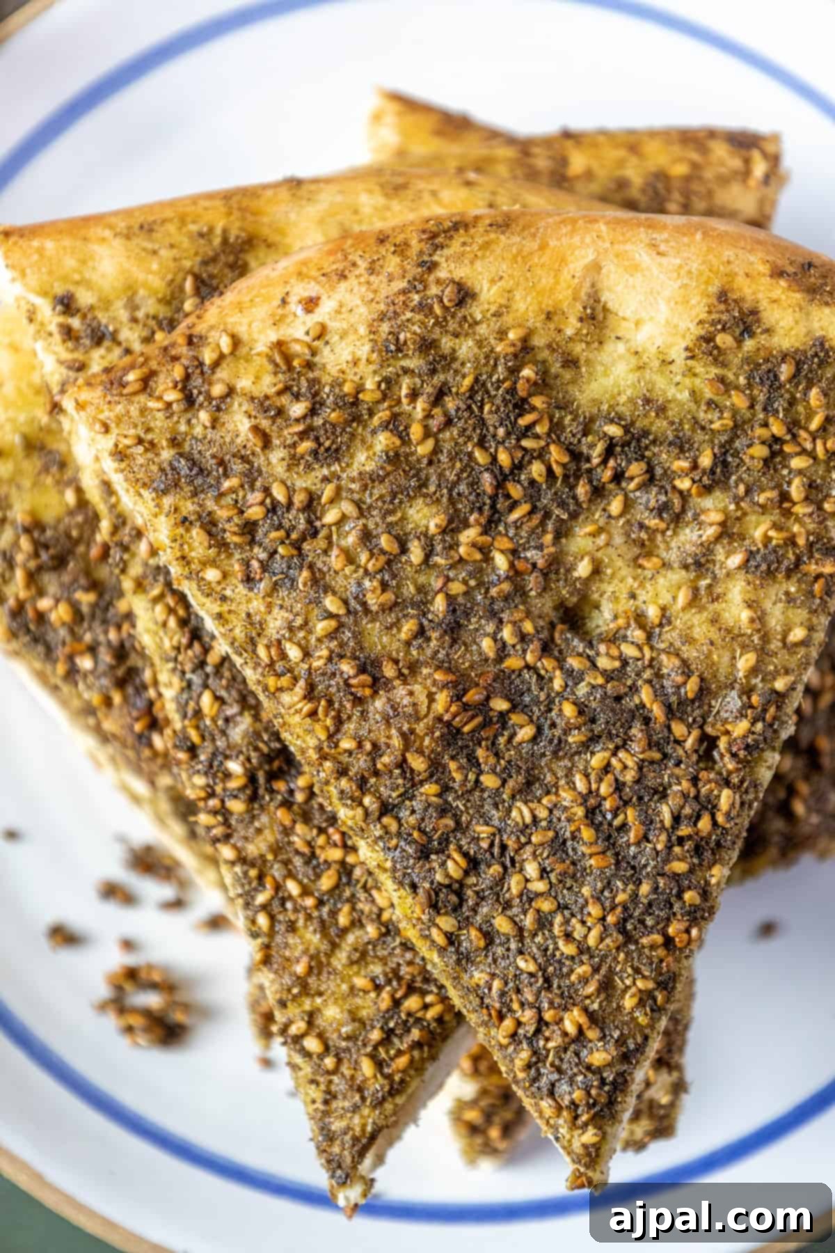 Aromatic Zaatar Pizza 2 A plate of bread with sesame seeds on it, known as a za'atar manakish or za'atar pizza.
