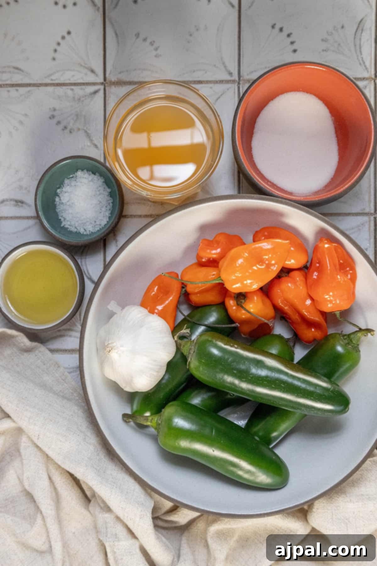 Spicy jalapeños and garlic with a sprinkle of salt on a plate, highlighting their texture.
