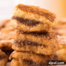 A stack of golden Nutella Stuffed French Toast Bites on a plate, ready to serve.