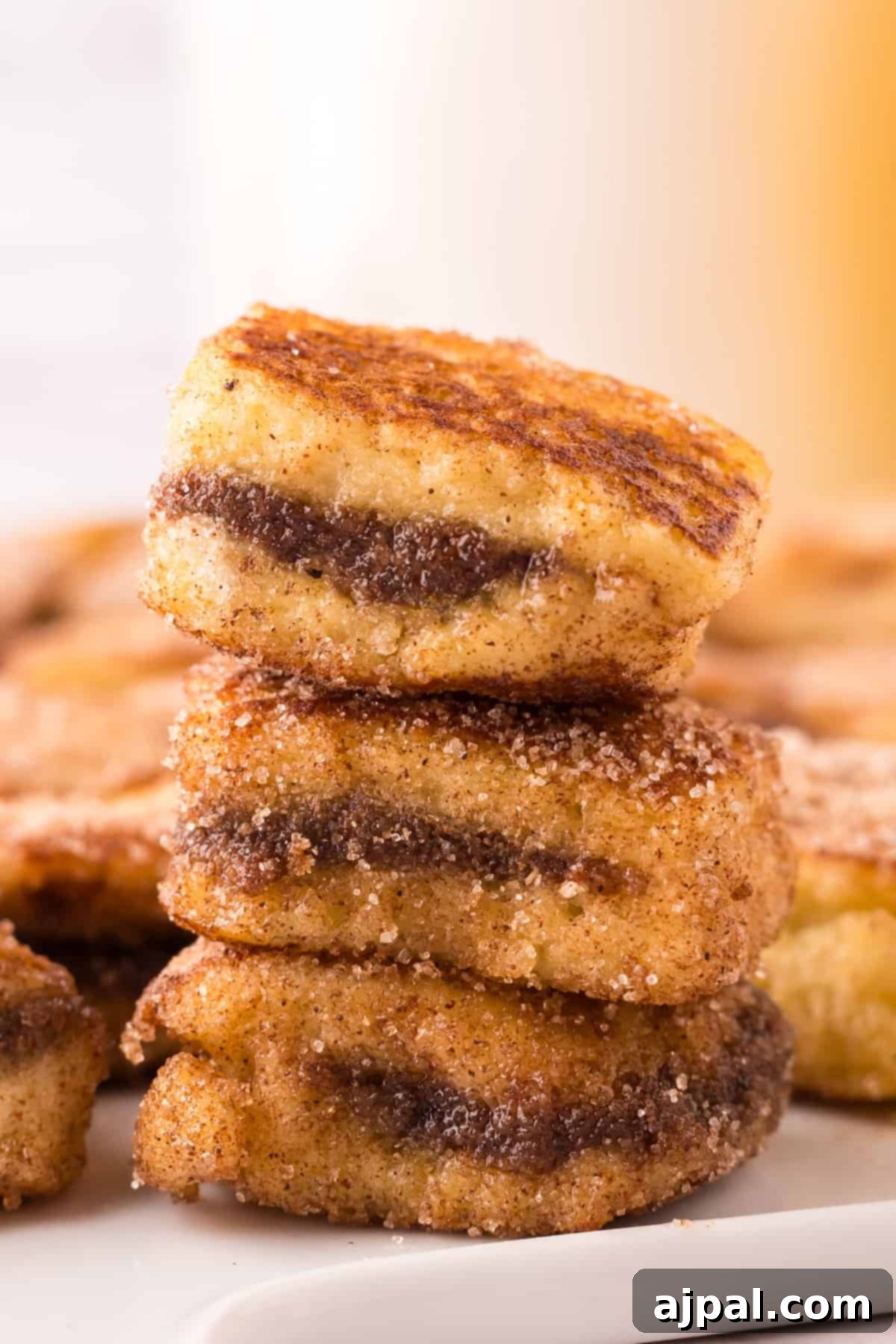 A stack of perfectly cooked and coated stuffed French toast bites on a plate, ready to be enjoyed.