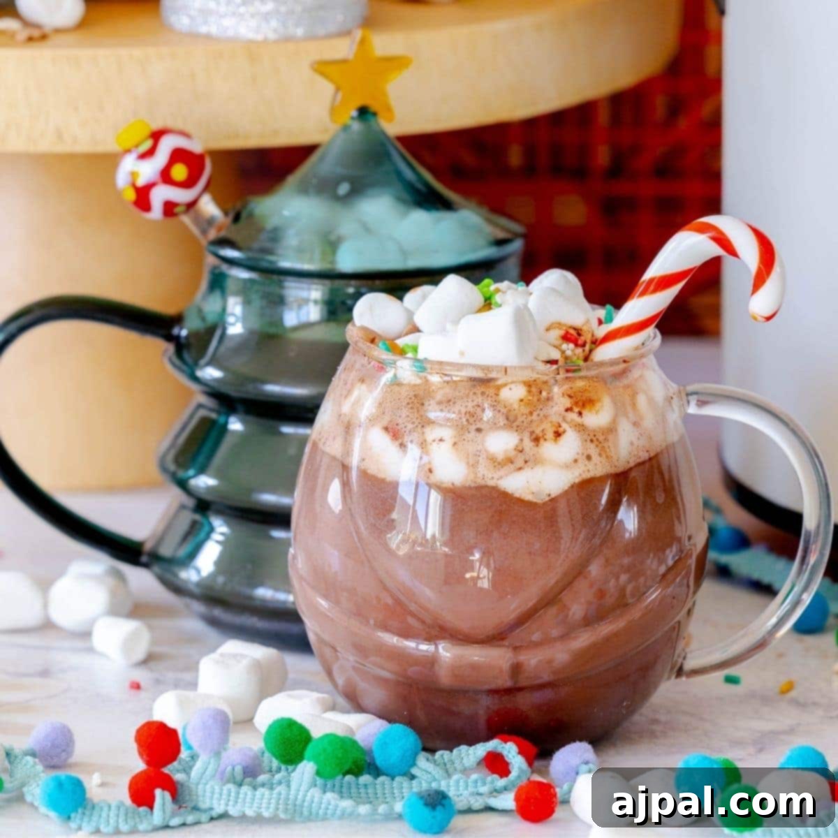 picture of mug with hot chocolate with candy cane stirrer and mini marshmallows on top