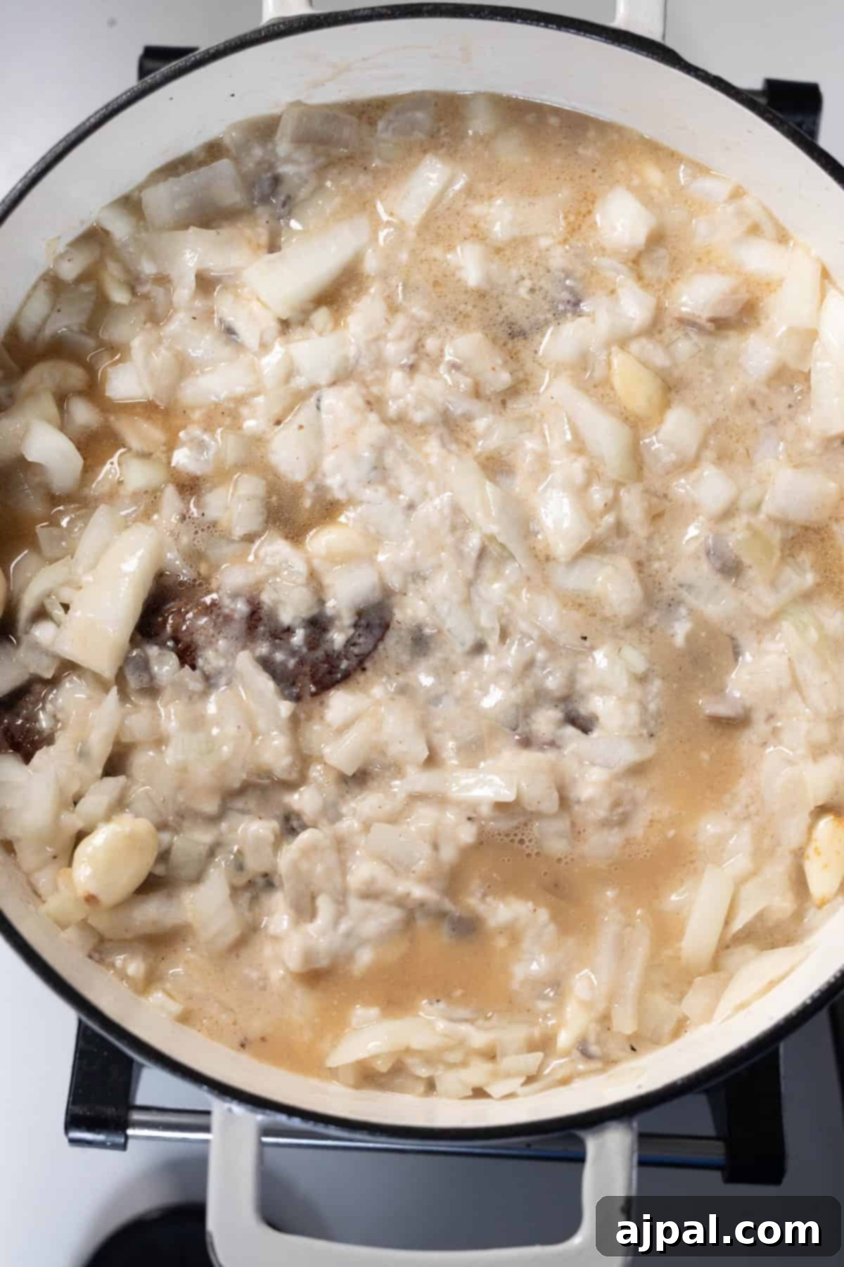 Simmering Onion Soup with meat and vegetables in a pot.
