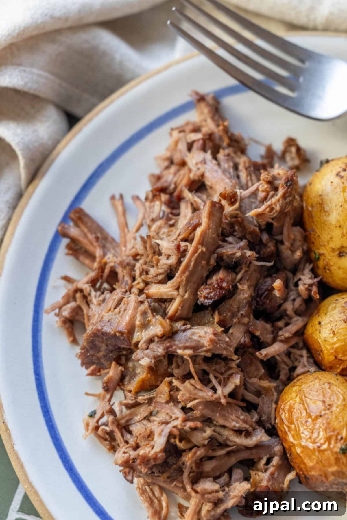 Shredded Slow Cooker Chuck Roast served with roasted potatoes