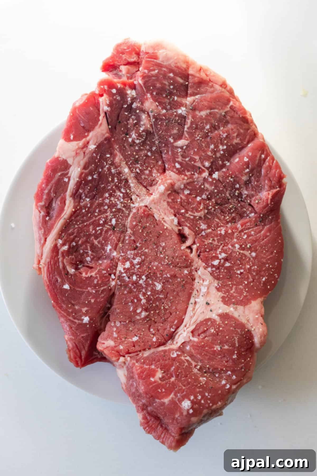 Raw beef steak seasoned with salt and pepper