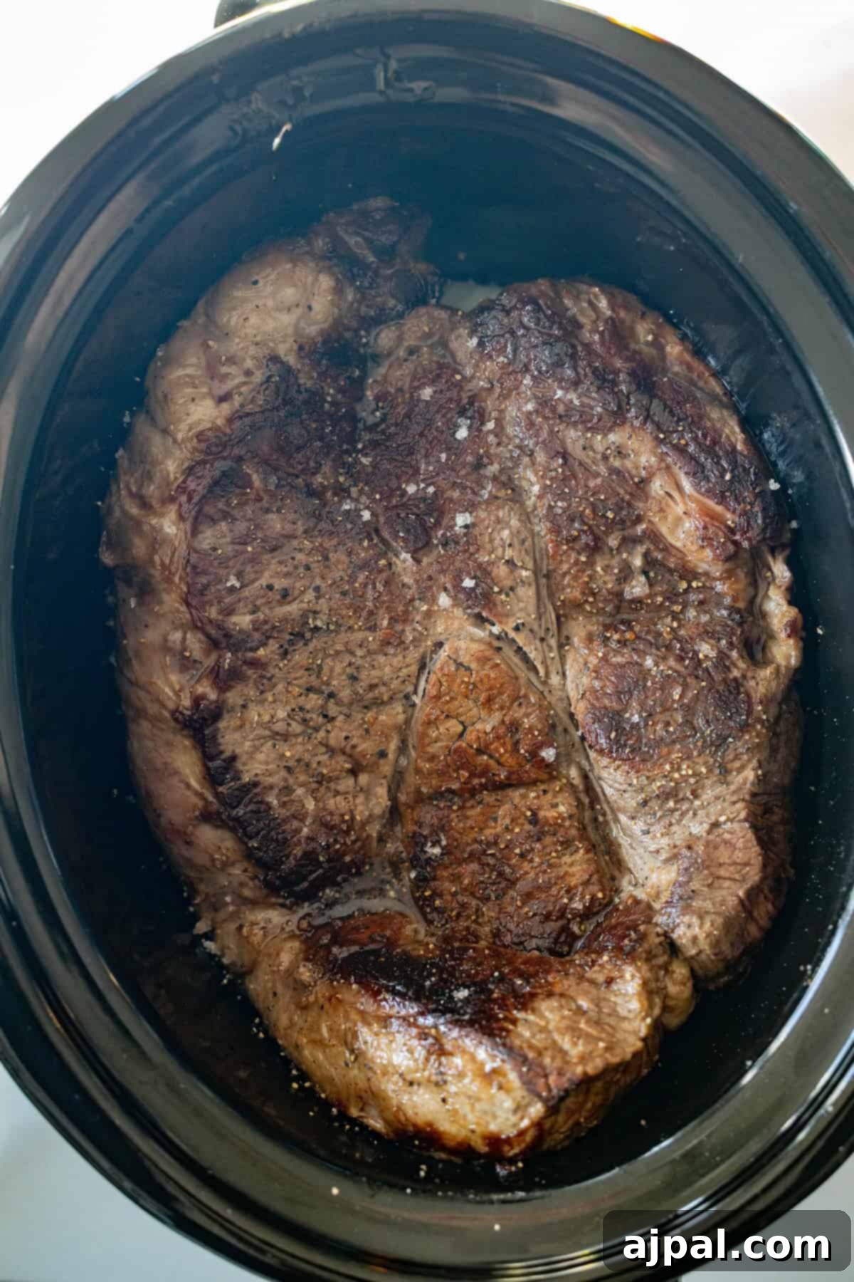 Browned slow cooker chuck roast on top of vegetables