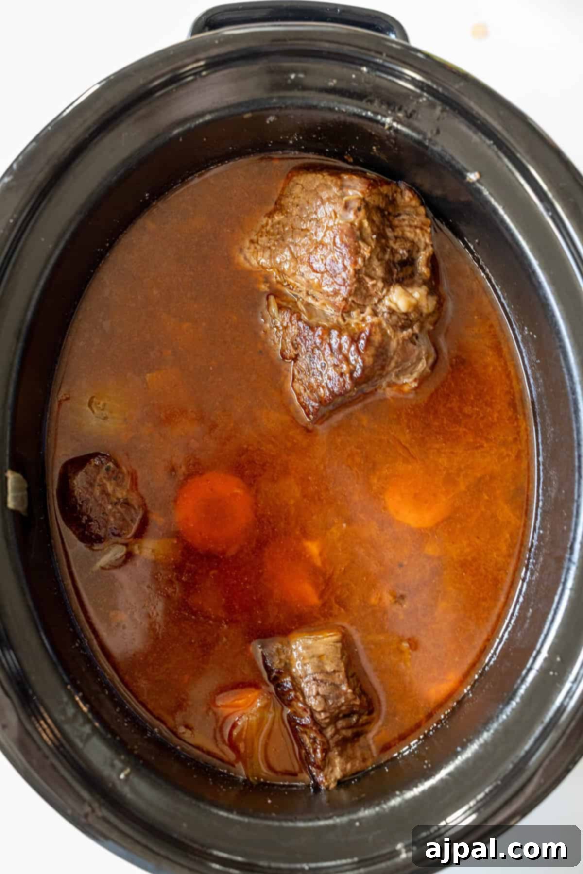 Slow Cooker Chuck Roast and vegetables simmering in broth