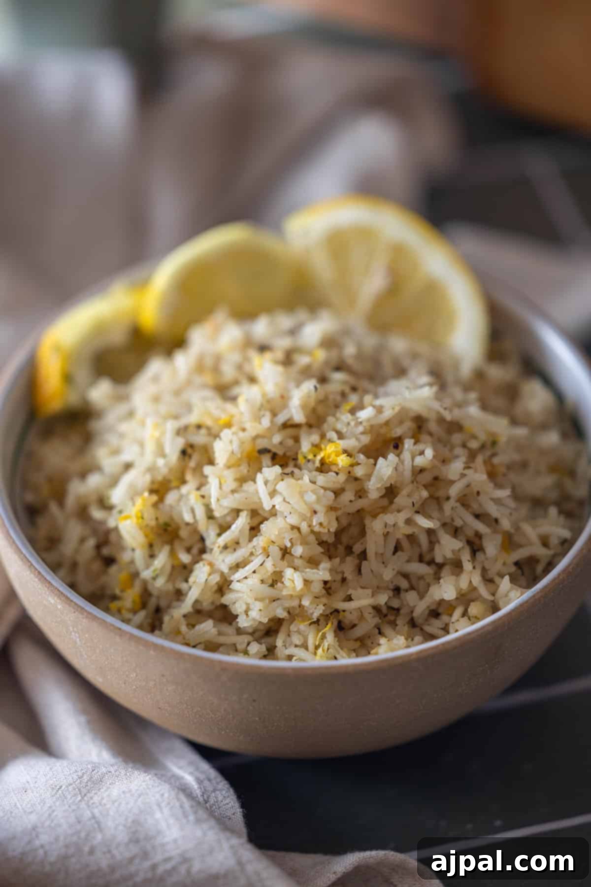 A bowl of Baked Lemon Rice garnished with lemon zest and lemon slices.