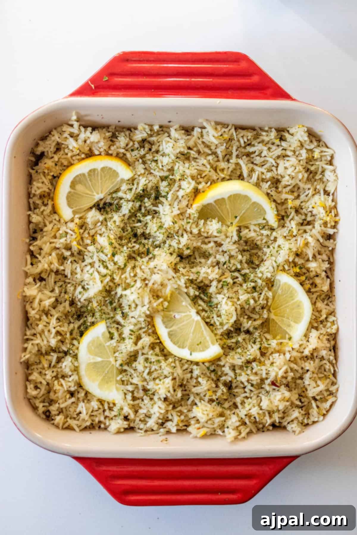 Baked lemon rice garnished with lemon slices and herbs.