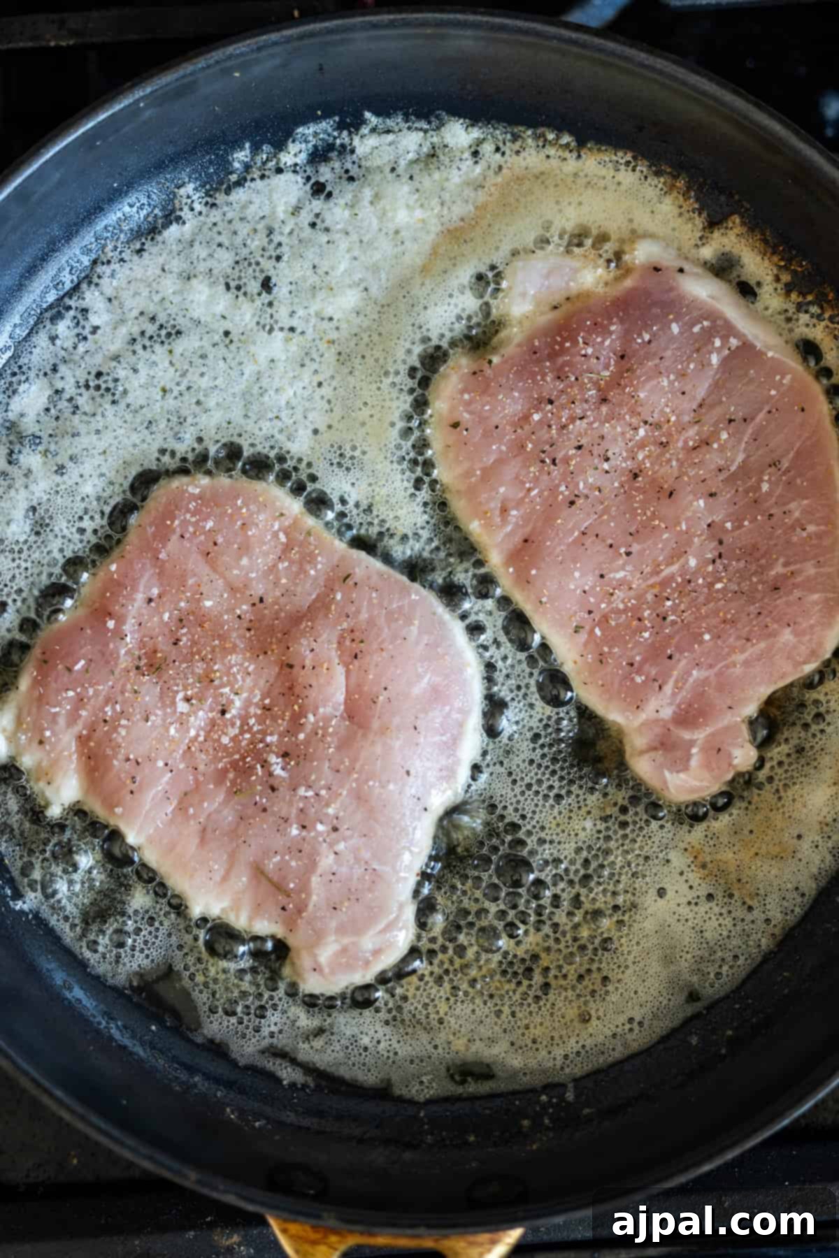 Pork chops sizzling in butter and garlic