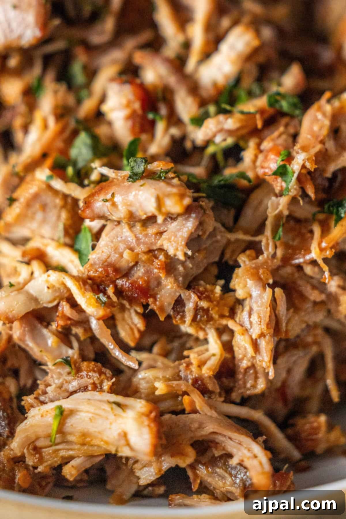 Piri Piri Spiced Country Ribs 2 Close-up of shredded, cooked pork with herbs, featuring tender Country Style Ribs.
