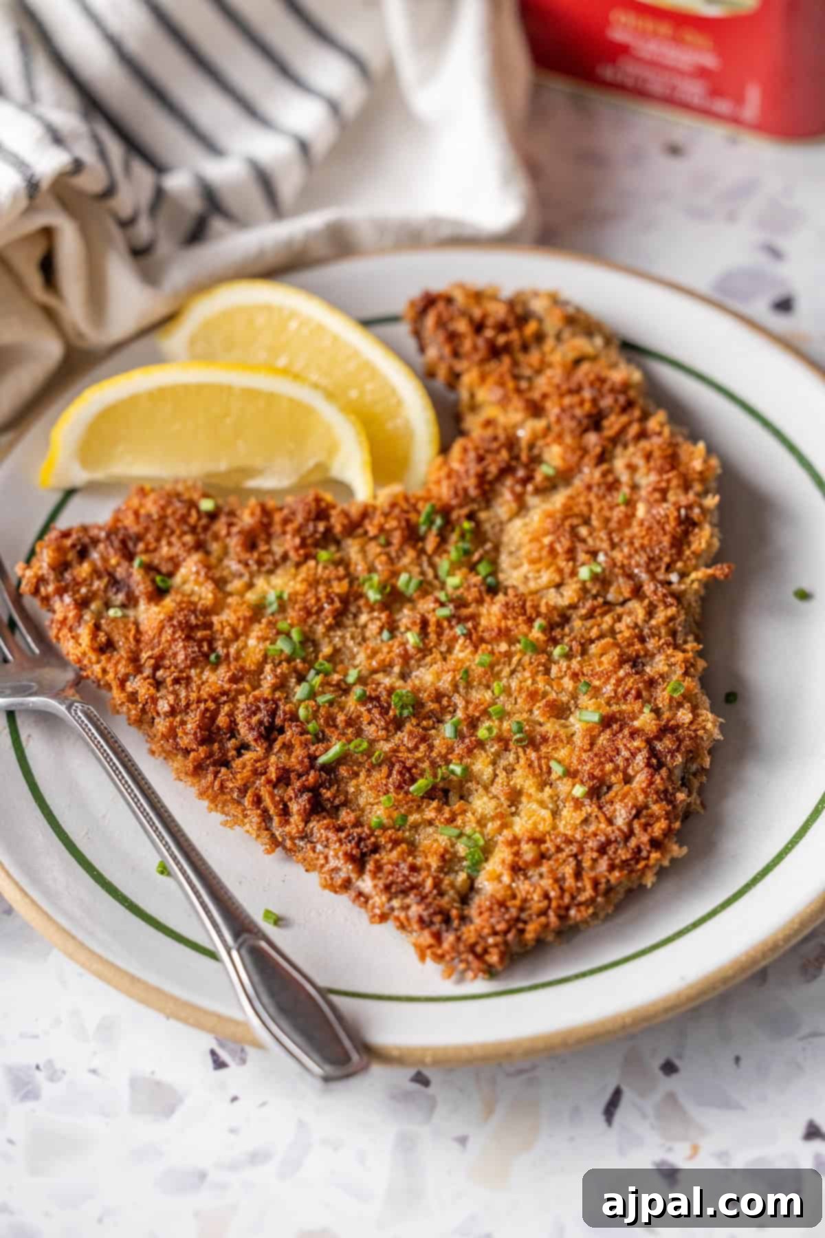 Golden Beef Milanesa with herbs and lemon wedges