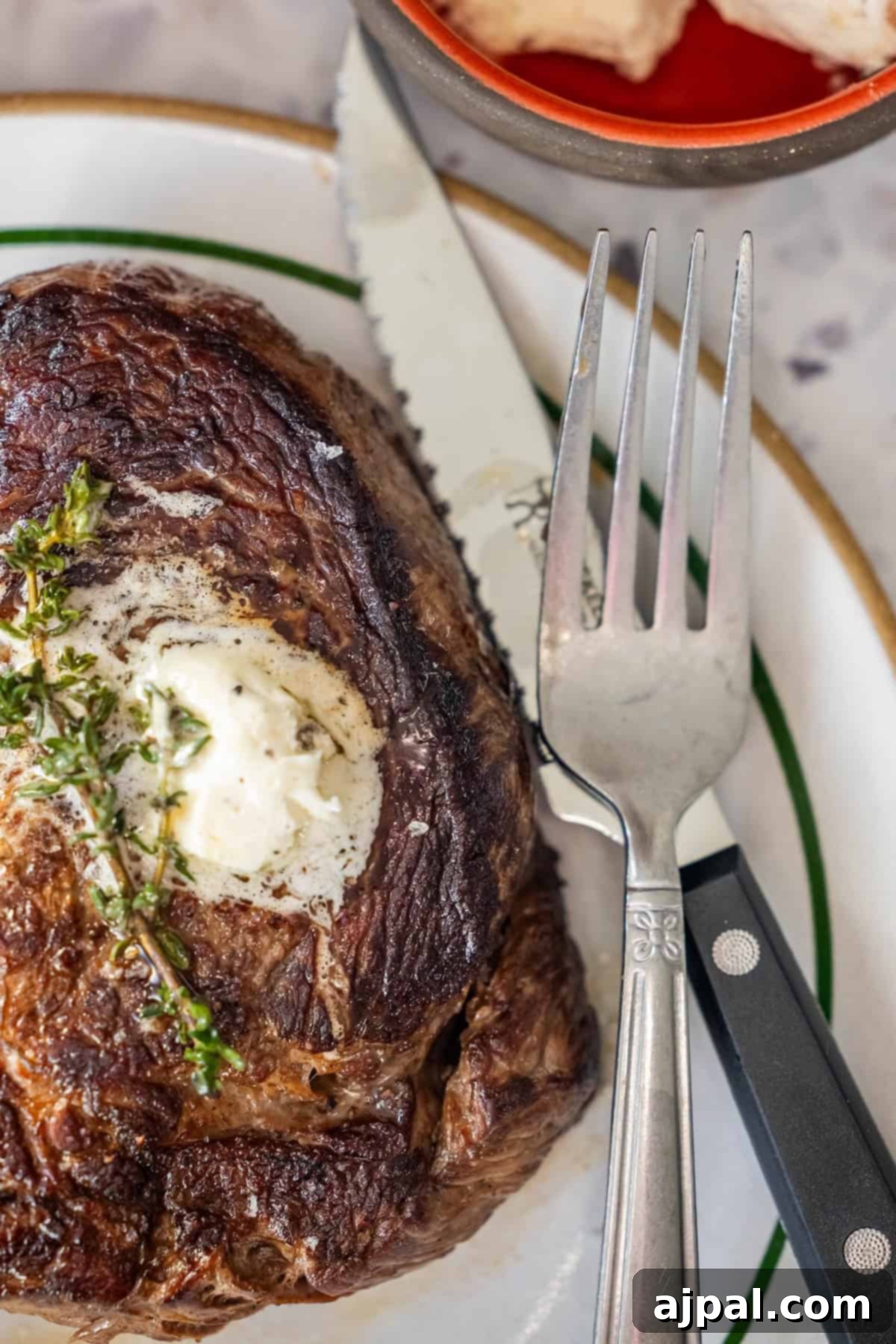 Perfectly cooked sirloin steak with herb butter and thyme.