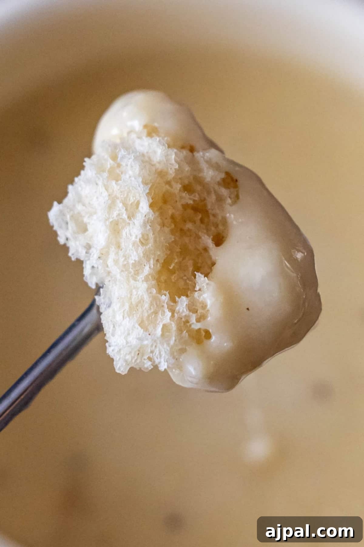 Bread dipped in cheese fondue close up