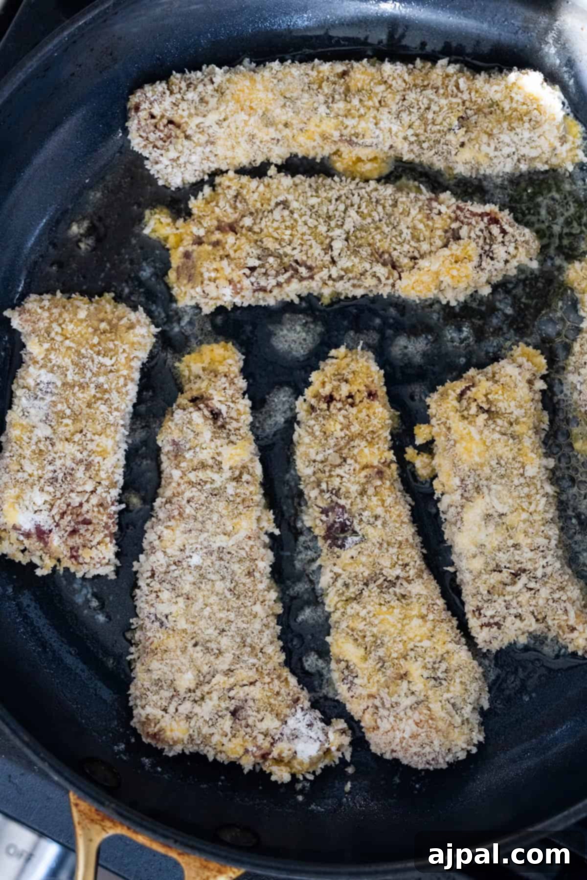 Pan-frying breaded steak strips in a skillet