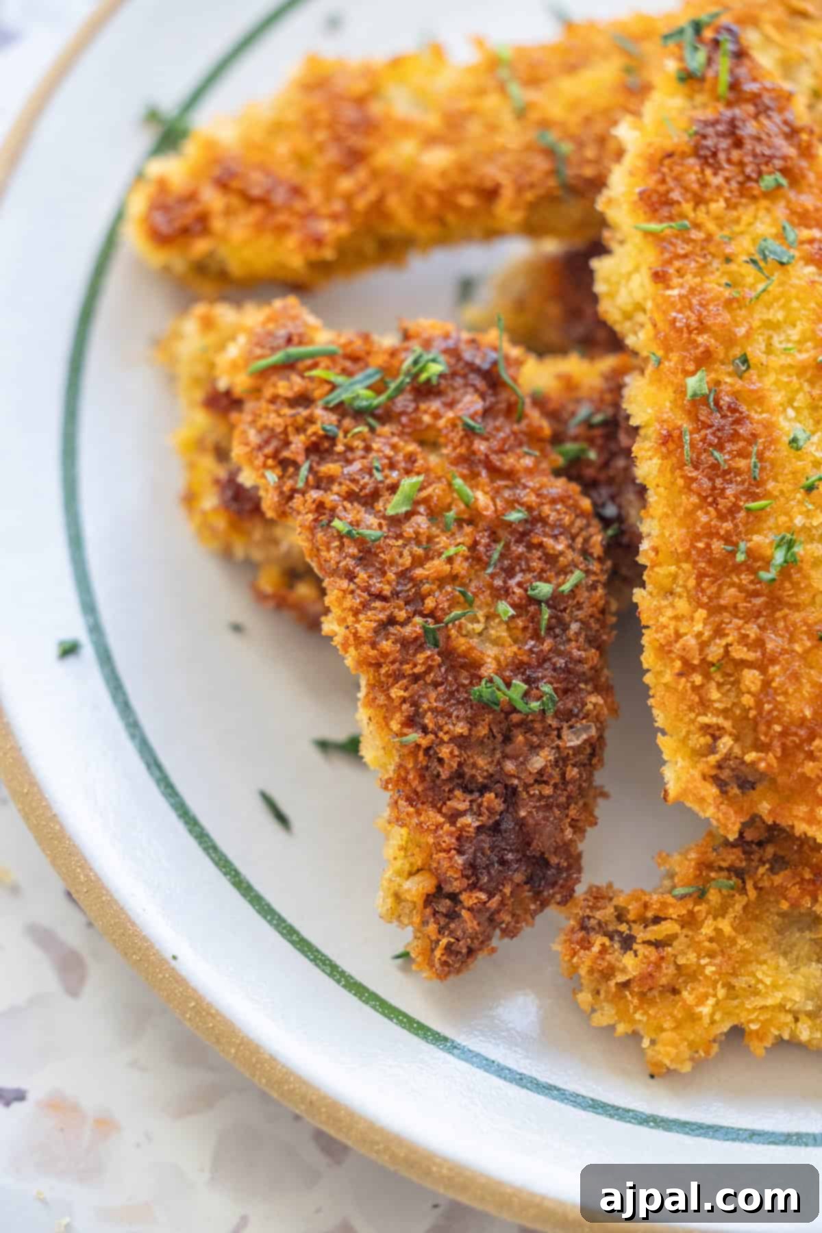 Plate of steak fingers garnished with fresh herbs